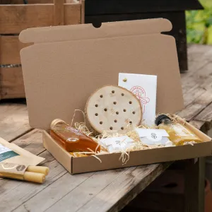 Open cadeaudoos met honing en een bijenhotel